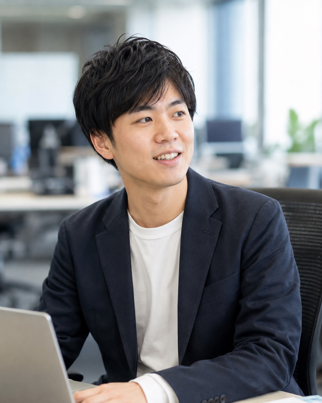 ノートパソコンを前に考える社員